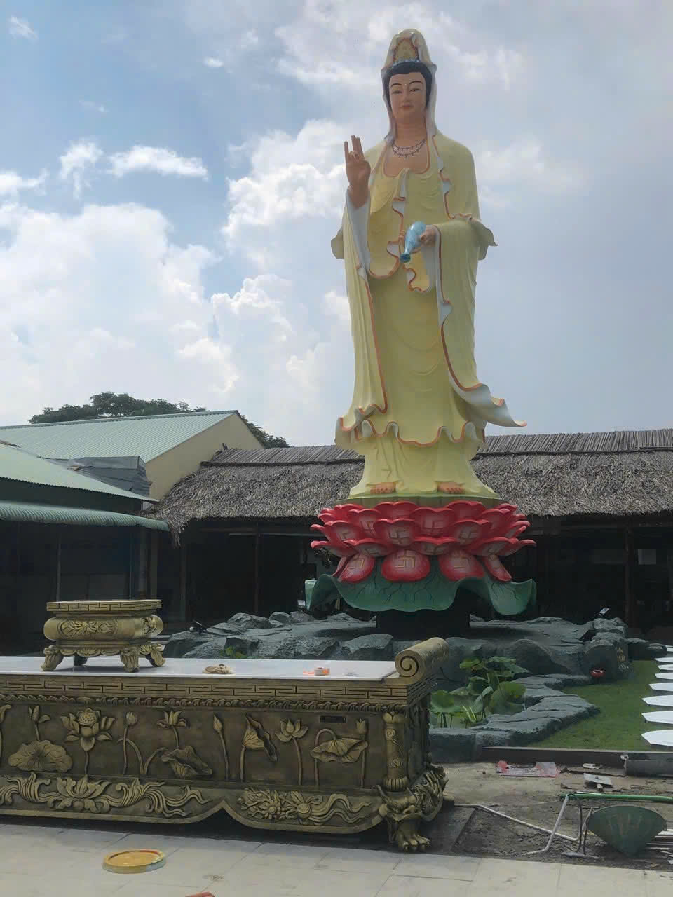[Cận cảnh khuôn mặt từ bi nhân hậu của tượng Quan Âm Bồ Tát bằng xi măng ngoài trời]